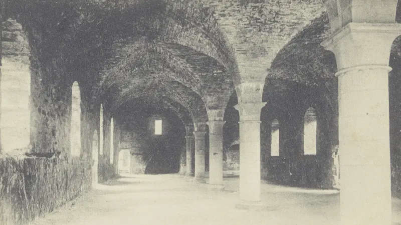 Ancienne carte postale en noir et blanc de l'intérieur de la brasserie de l'abbaye de Villers-la-Ville : une grande salle voûtée soutenue par des colonnes de pierre