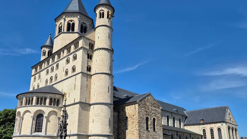 La collégiale Sainte-Gertrude de Nivelles et la fontaine du Perron, sous un ciel bleu